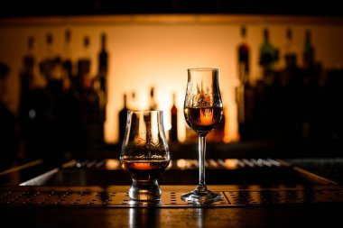 Harika bir manzara, bardağın yarısı dolu bardaklar ve bardakta alkollü içkiler. Uzayı kopyala Bulanık arkaplan