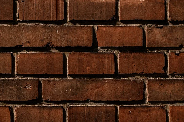 Close-up dark red brick wall. Abstract background texture and seamless pattern. Wallpaper of dark brown brick