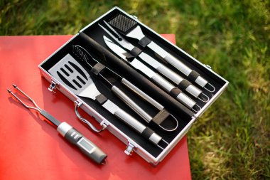 Barbekü araçlarının en üstteki görüntüsü. Barbekü çelik aletler seti, maşa, spatula, çatal. Yakın plan..