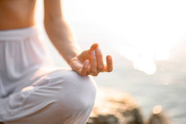 close-up of hands, gyan mudra and lotus position, woman practicing yoga. Fragment of woman practicing yoga