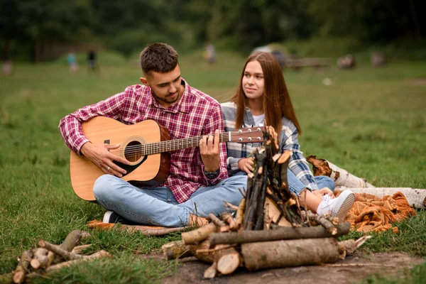 Romantic music and happy young couple relationships. Man with guitar. Love story. Romantic vacation in nature
