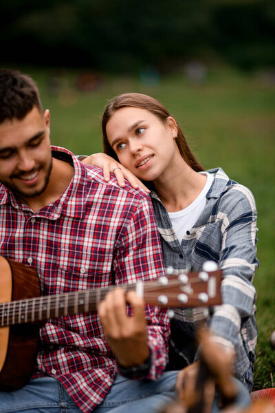 close-up of beautiful young woman and man with guitar. Happy couple relationships. Romance couple with guitar. Love story.