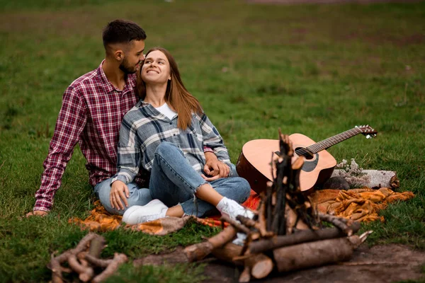 公園でリラックスした若い笑顔の男と女 幸せなカップル関係 ギターとロマンスのカップル ラブストーリー — ストック写真