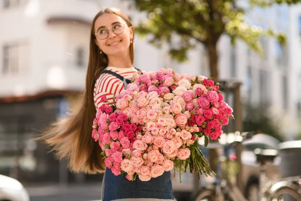 미소를 여인이 분홍빛 아름다운 꽃다발 — 스톡 사진