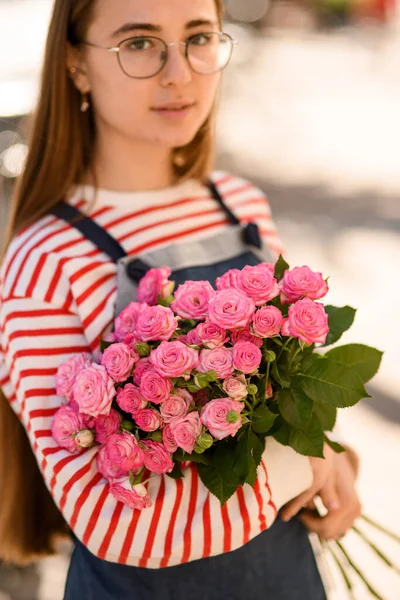 อกโฟก อดอกก หลาบส ชมพ สดใสสดใสในม อของหญ งสาวสวยในแว นตาท ผมยาว — ภาพถ่ายสต็อก