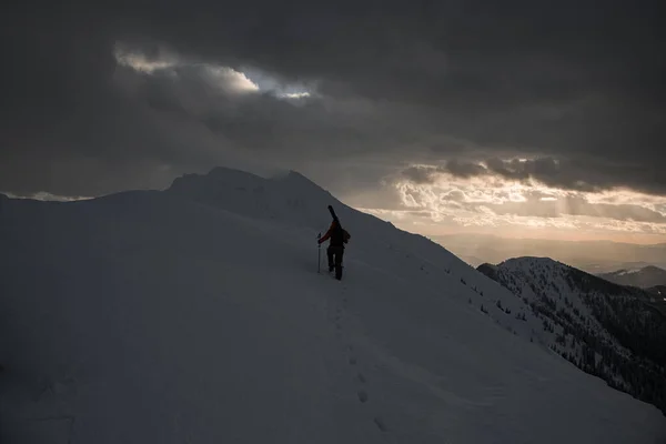 白い深い雪で雪に覆われた山脈を歩いているスキーヤーのリアビュー スキーツアー — ストック写真