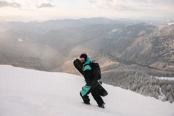 Turista Traje Esqui Com Snowboard Suas Mãos Caminha Encosta Coberta — Fotografia de Stock