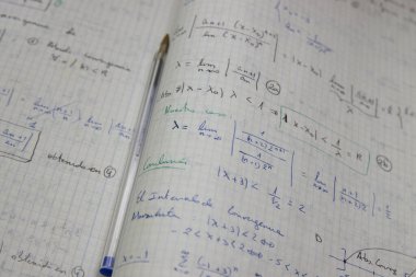 Üzerinde mavi bir kalem bulunan matematiksel limitlerin çözülmüş alıştırmalarına sahip bazı sayfaların resmi