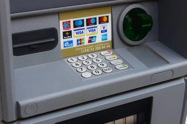 Şubat 2022. Valencia, İspanya. Klavyenin ayrıntıları, kredi kartının yerleştirildiği yer, banknotların çıkış yeri sokaktaki bir ATM 'de kabul edilen kartların yanında.