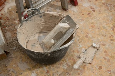 Bazı tuğla ustalarının aletlerine yakın çekim, bir mala, bir mala ve iç duvarı göstermek için kullanılan bir sepet.