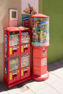 2022. Valencia, Spain. Close-up of some gum and toy vending machines in a downtown street of a city