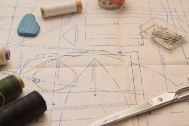 Kalıplı bir görüntü, iğne, iplik ve makas kumaş kesmek için kağıt üzerindeki deseni takip eden giysiler yapmak için. Model için merkezde boşluk kopyala