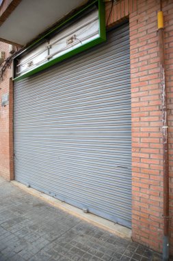 Image of a commercial premises that has closed, has removed the light and has the blind permanently lowered