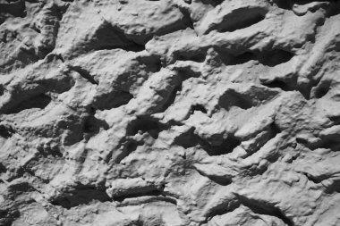 Close-up of an old wall or wall that has a rock texture of gray colors with contrast between light and shadow