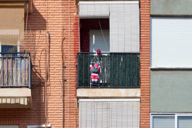 Noel 'de balkona asılmış küçük bir Noel Baba resmi.