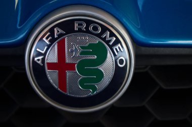 Mavi arabalarından birinin önünde bir Alfa Romeo 'nun logosu ve damgası var.