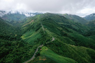 Nan, Tayland 'da yeşil ormanlı dağların tepesindeki güzel gökyüzü yolunun hava manzarası..