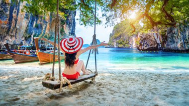 Bikinili kadın Ko Lao iniş adasında salıncakta dinleniyor, Krabi, Tayland.