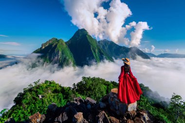 Tourist standing on Pha Dang viewpoint at sunrise in Muang Ngoy, Laos.