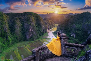 Hang Mua bakış açısında oturan kadın turist. Tam Coc, Ninh Binh 'in popüler turistik merkezi. Vietnam.