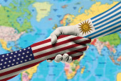 Kézfogás között Egyesült Államok és Uruguay zászlók festett kézre.With háttér világtérkép