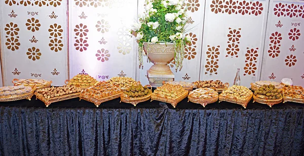 顶部的照片是一大盘摩洛哥杏仁和奶油饼干 上面覆盖着糖霜 在阿拉伯风味的盘子上装饰着生杏仁 通常与茶一起吃的甜茶糕点 — 图库照片