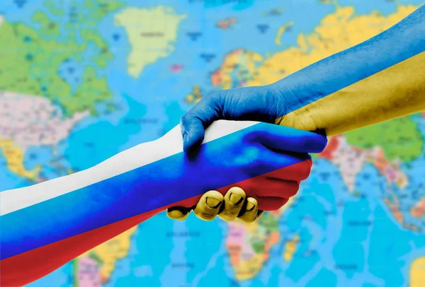ウクライナとロシアの旗は 世界地図の背景に手を振る — ストック写真