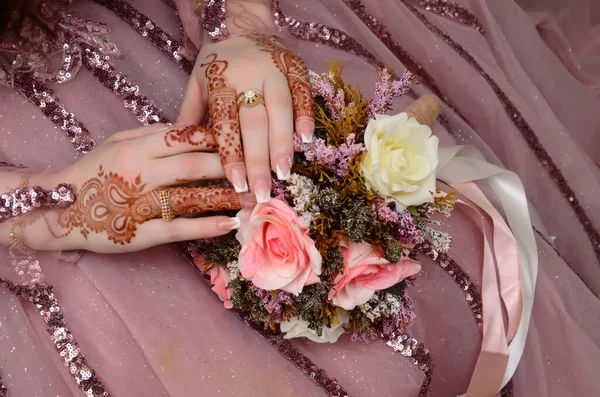 Henna Tattoo on Bride's Hand.Moroccan wedding preparation henna party. Temperate white mehndi. Modern mehendi art