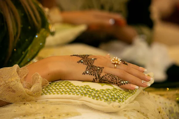 Henna Tattoo on Bride\'s Hand.Moroccan wedding preparation henna party. Temperate white mehndi. Modern mehendi art