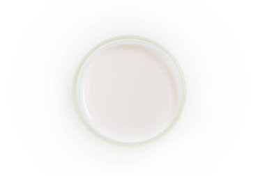 Beyaz arkaplanda izole edilmiş bir bardaktaki süt, üst görünüm.