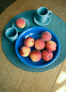 Tahta arka planda bir kasede taze şeftali