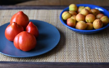 Taze kayısılar ve domatesler masada.