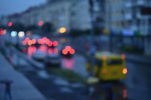 Evening city street with busy traffic and blurred bokeh lights
