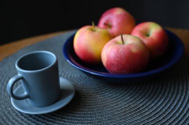Mavi bir tabakta elma ve fincanın yaşamı