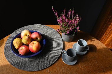 Meyve, seramik kaplar ve çiçeklerle dolu durgun bir hayat