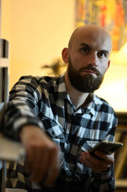 Ekose gömlekli kel sakallı adamın portresini kapat.