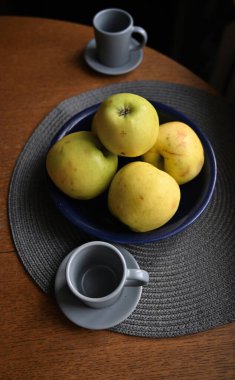 Bir fincan kahve ve olgun elmalar kasede