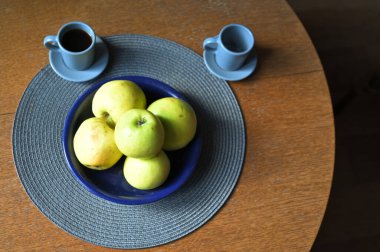 Bir fincan kahve ve olgun elmalar kasede