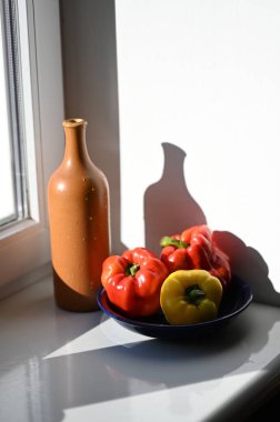 Olgun biberler. Pencere kenarında şişe.