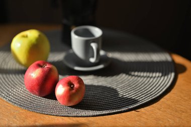 Kupa ve elmalar masada. 