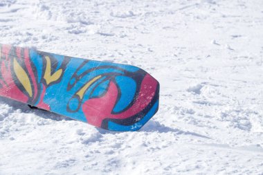 Dağdaki karlı zeminde kar kaykayı. Snowboard baş aşağı duruyor.