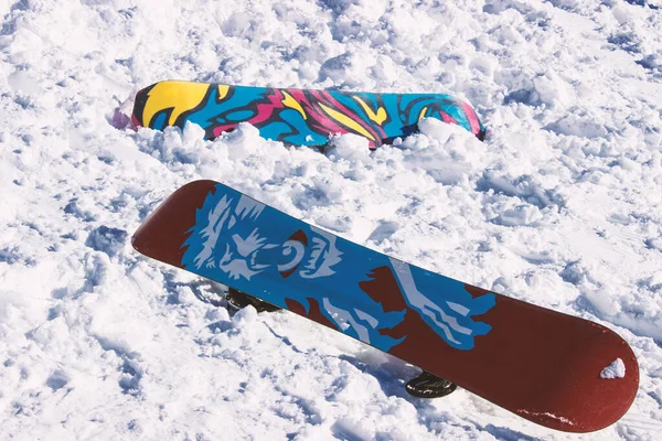Dağdaki karlı zeminde kar kaykayı. Snowboard baş aşağı duruyor.