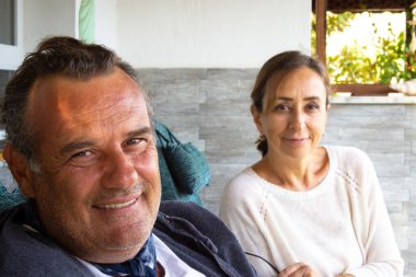 Orta yaşlı çift gülümsüyor ve kameraya bakıyor. Emekli çift birlikteliği kavramı. Her gün insanlar...
