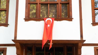 Geleneksel bir Türk evinin camında Türk bayrağı asılı. 29 Ekim veya 23 Nisan, 30 Ağustos 'u kutluyoruz. Türkiye Ulusal Bayram Konsepti.
