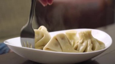 Geleneksel Gürcistan hamur tatlısı, khinkali, tabakta yatar. çatalla dokunmuş.