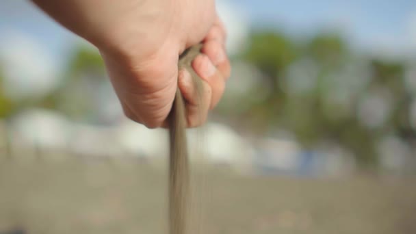 Mâna strânsă apucă o mână de nisip uscat și îl lasă să cadă între degete — Videoclip de stoc