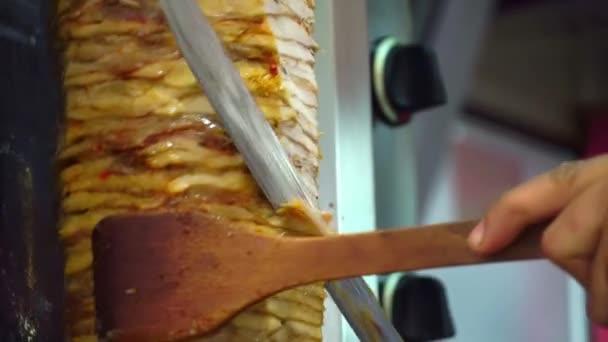 Seorang juru masak memotong daging untuk membuat shawarma, gyros, doner kebab. Memasak daging dengan tusuk sate. — Stok Video