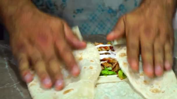 Mäns händer lägger grönsaker och kyckling kött på pitabröd för att laga mat rulla, — Stockvideo