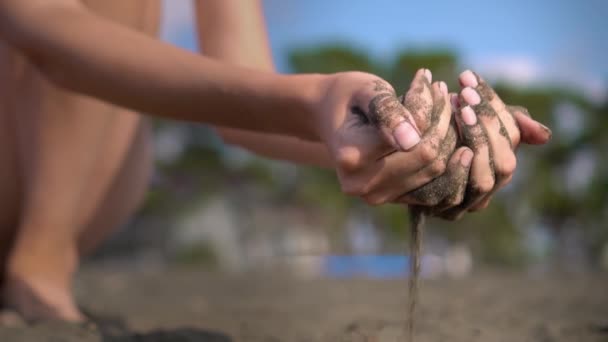 Mano de cerca agarra un puñado de arena seca y deja caer entre sus dedos — Vídeos de Stock