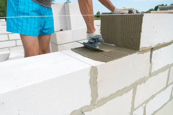 Builder Menggunakan Sekop Berlekuk Untuk Mengaplikasikan Campuran Semen Blok Beton — Stok Foto